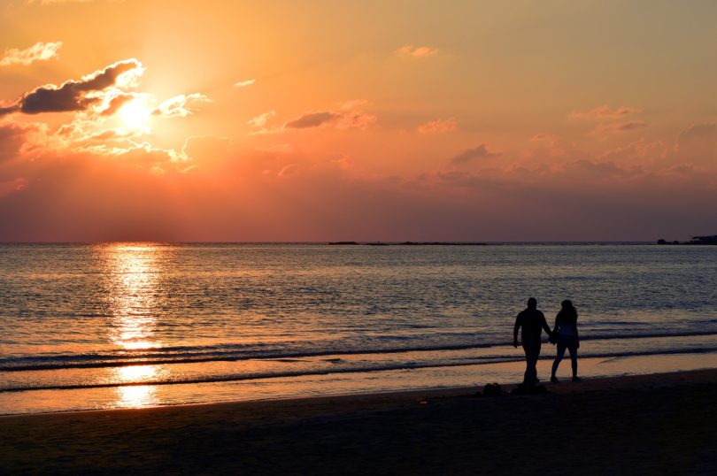 A couple walking on a beach with holding hands